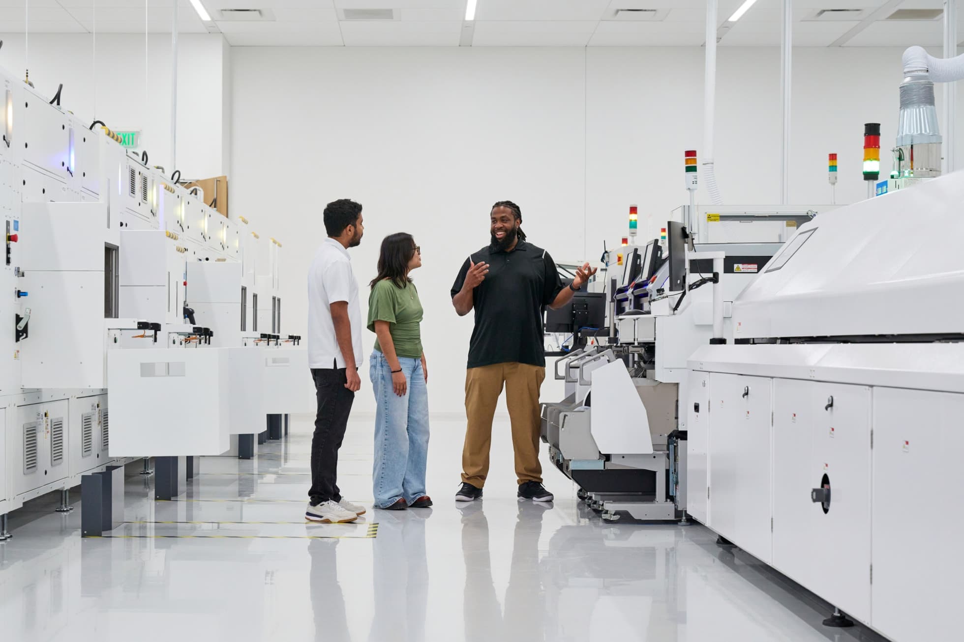 Tre personer på fabrikkgulvet ved Apples Advanced Manufacturing Center i Houston.