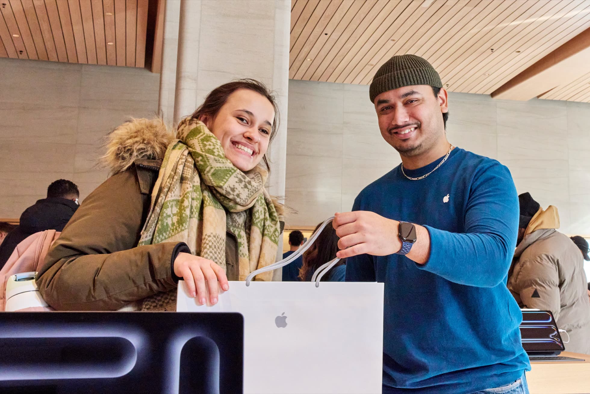 En Apple-ansatt gir en kunde en hvit Apple-pose inne i Apple Sainte-Catherine i Montreal.