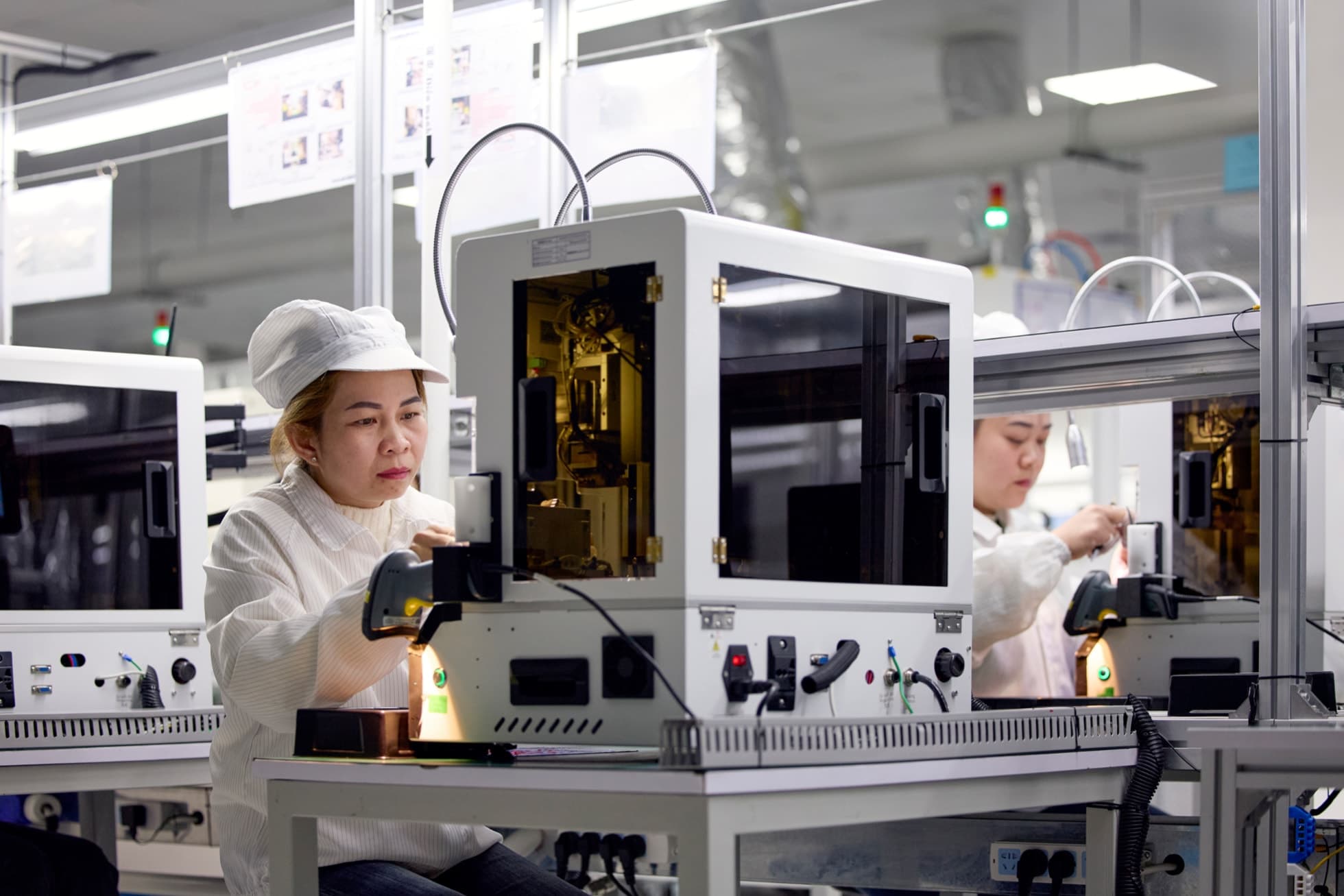 To leverandøransatte arbeider ved produksjonsutstyr i et laboratorium i Vietnam.