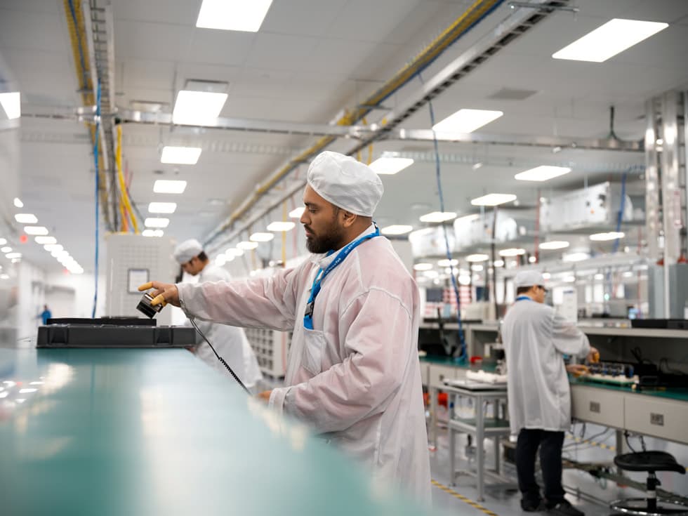 Tekniker bruker et håndverktøy ved en arbeidsstasjon i Apples produksjonsanlegg i Houston.