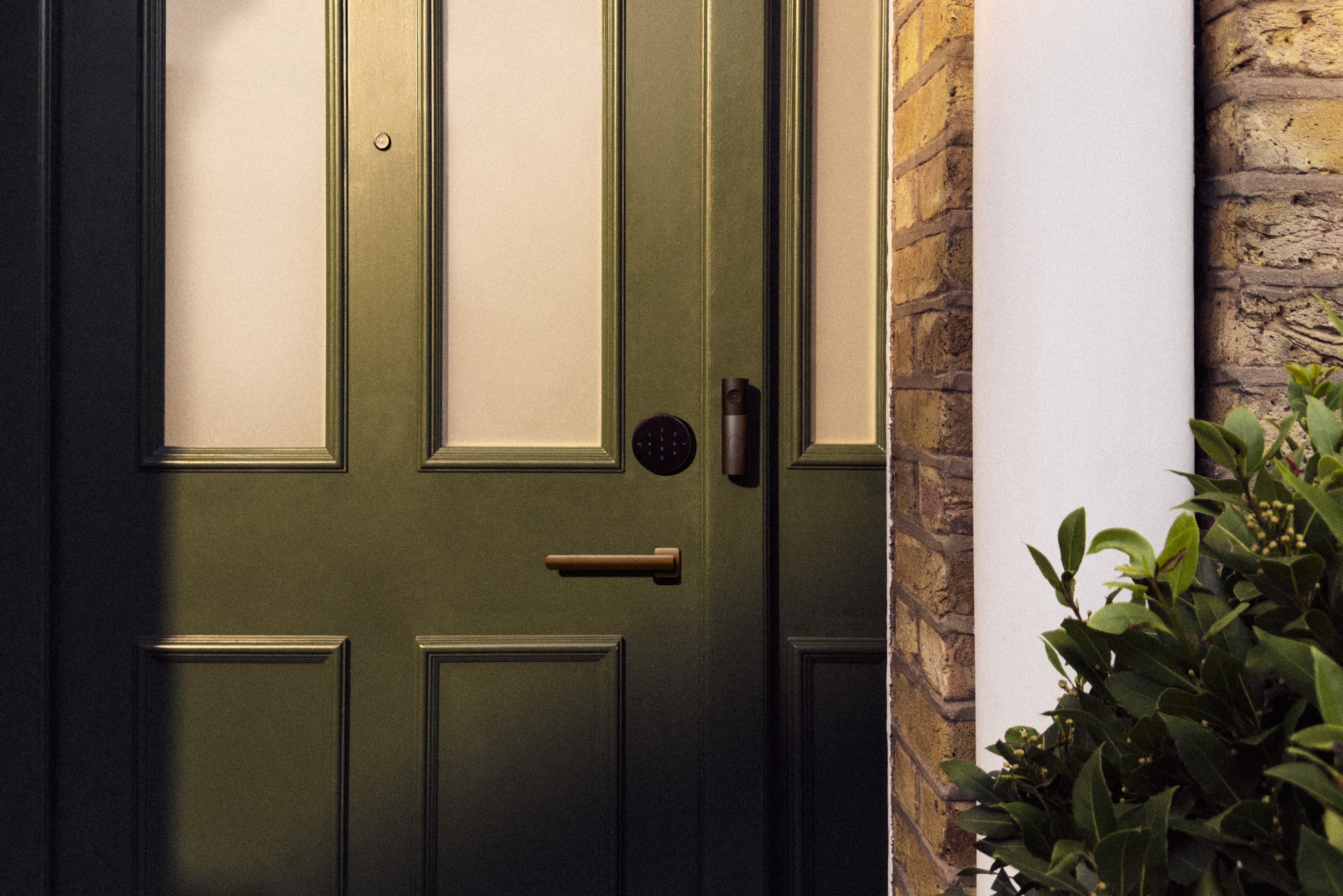 LG Smart Deadbolt Lock og LG Video Doorbell montert på en grønn ytterdør.