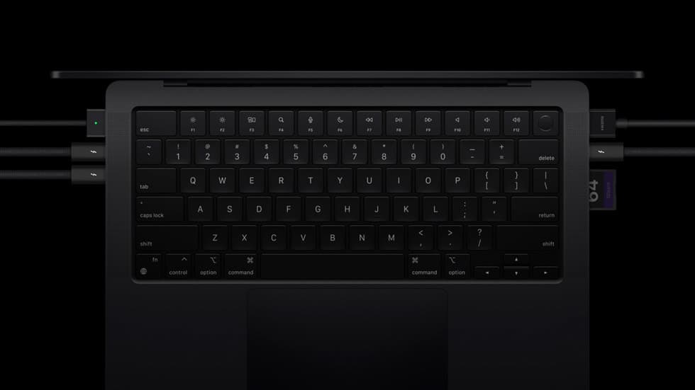Kabler og minnekort koblet til portene på en MacBook Pro med M4-brikke, sett ovenfra
