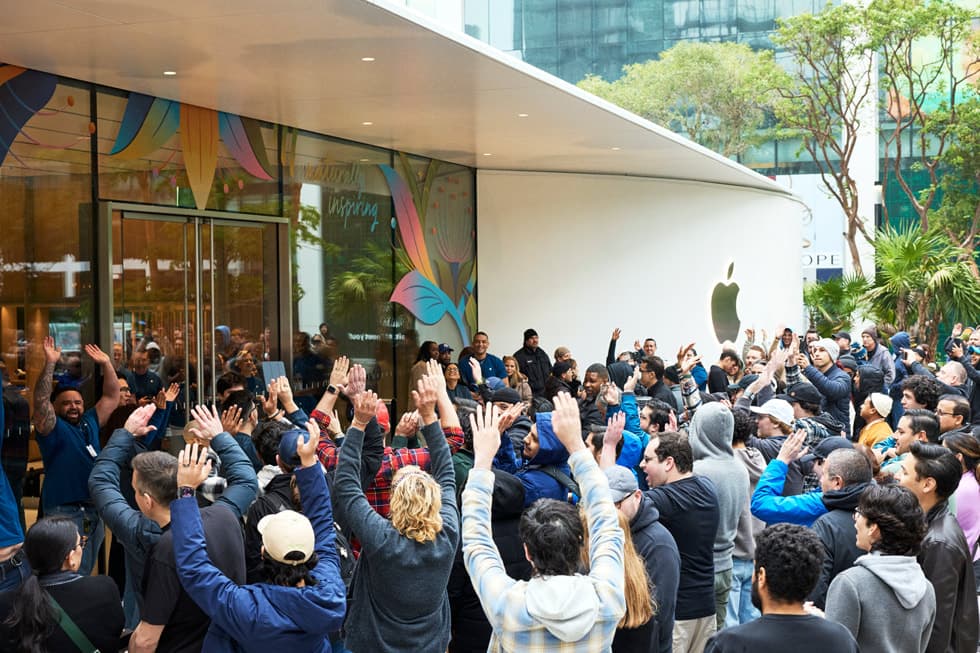 Folkemengde med kunder samlet utenfor Apple Store Miami Worldcenter med Apple-logoen synlig pa fasaden.