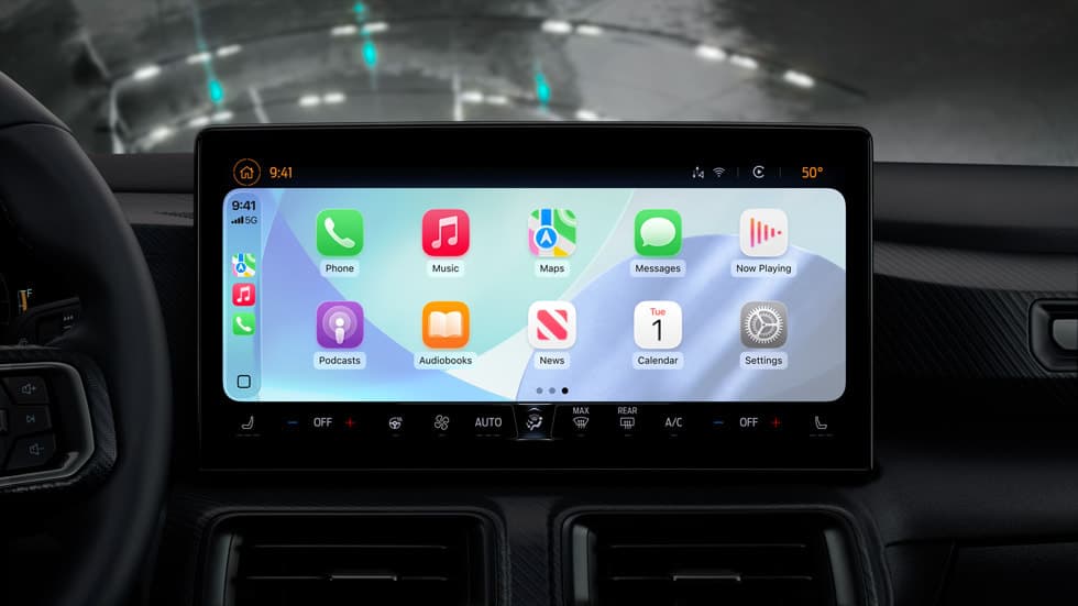Apple CarPlay-hjemmeskjerm i iOS 26 vist på en bils infotainmentskjerm med app-ikoner for Telefon, Musikk, Kart og Meldinger