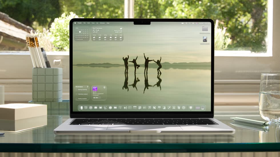 MacBook Air med macOS-skrivebordet og Finder-menylinjen, på et lyst skrivebord hjemme